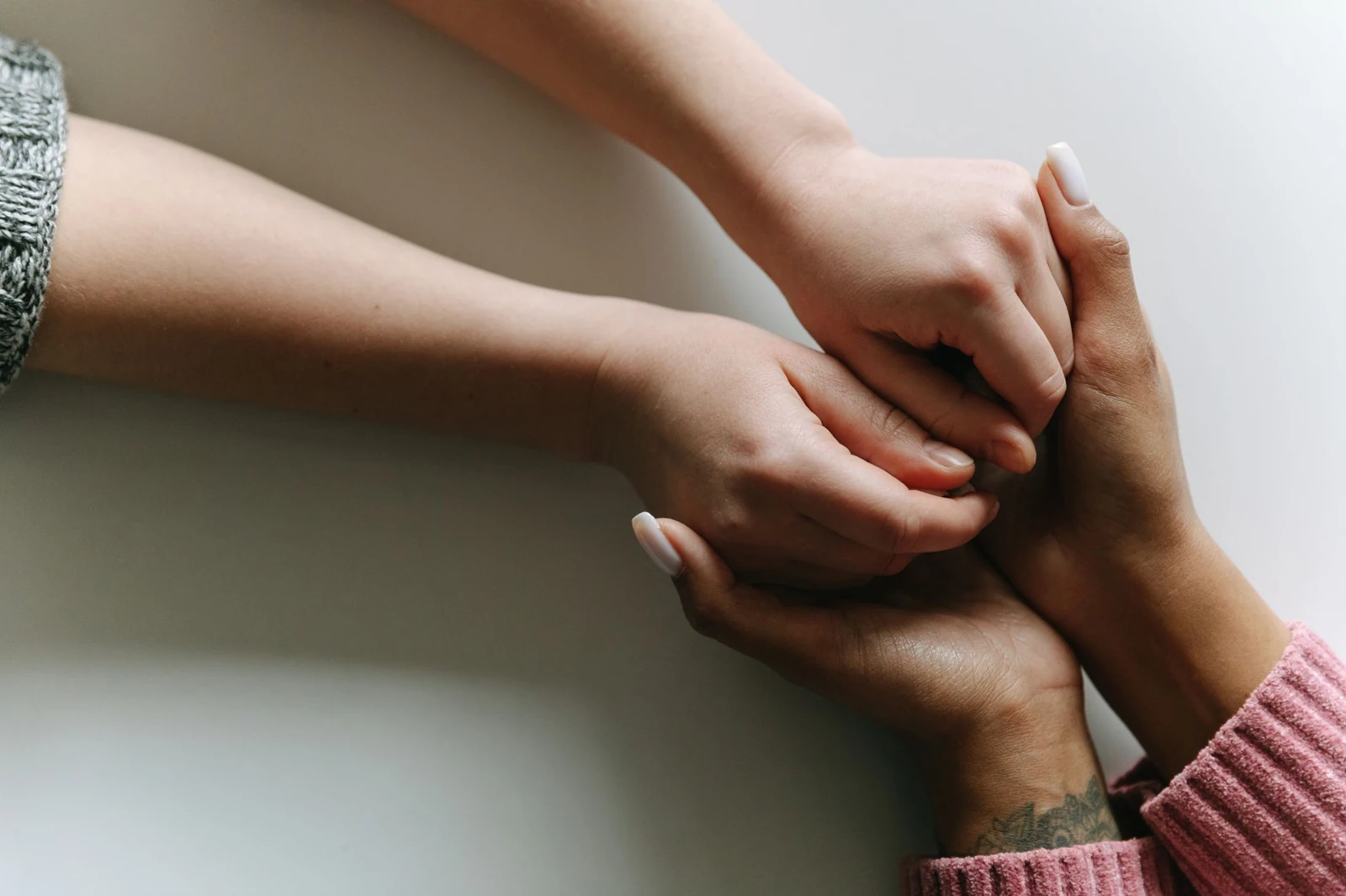 Deux personnes se tiennent les mains dans un geste de soutien.